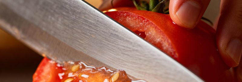 Knife slicing a ripe tomato in close-up — food safety controls checked during an FSSC 22000 Version 7 internal audit